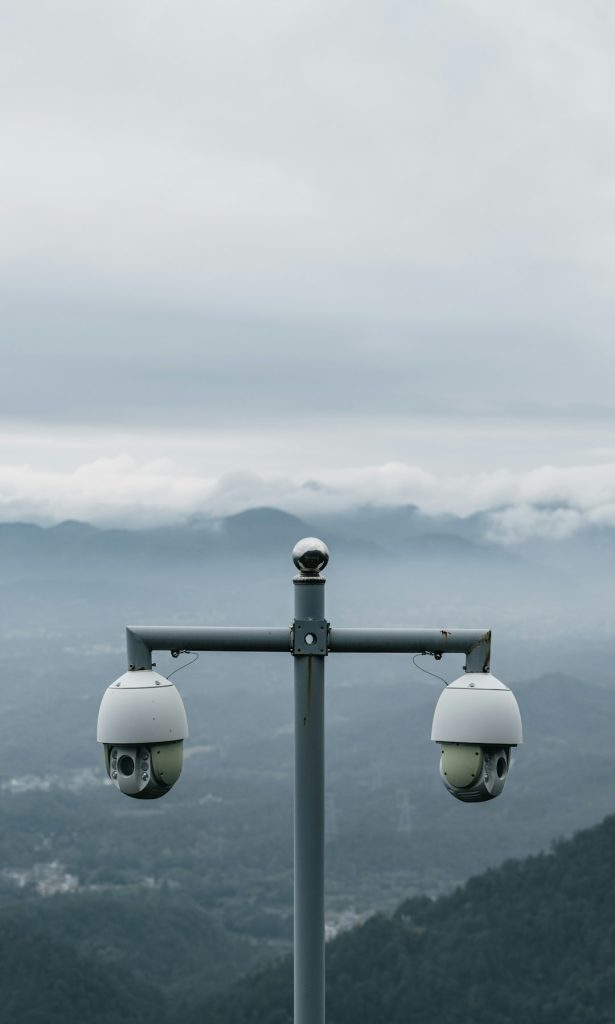 two-surveillance-cameras-on-a-pole-with-mountains-behind-i8qmddvzt4e